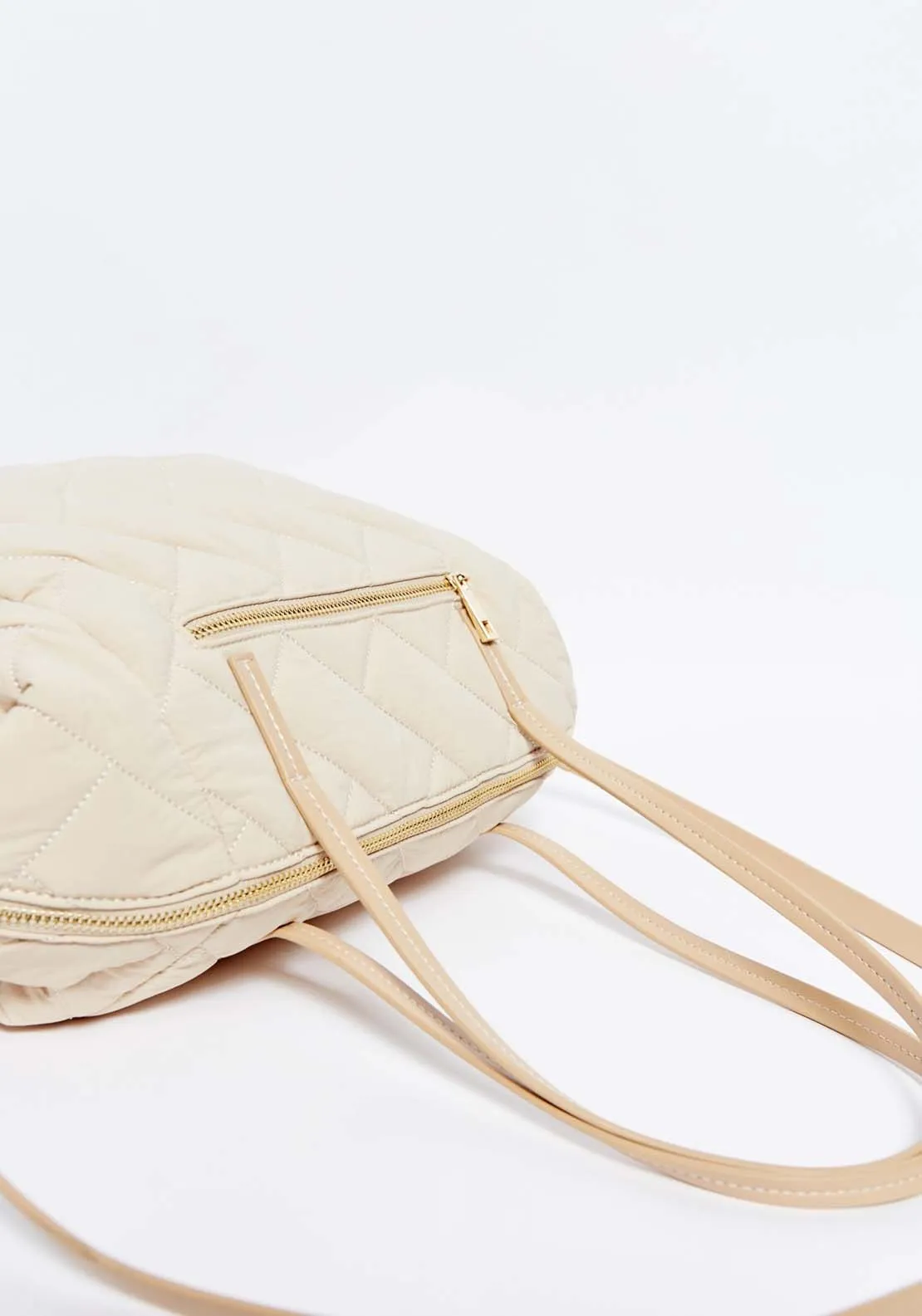 Beige nylon bowling bag with quilted design.